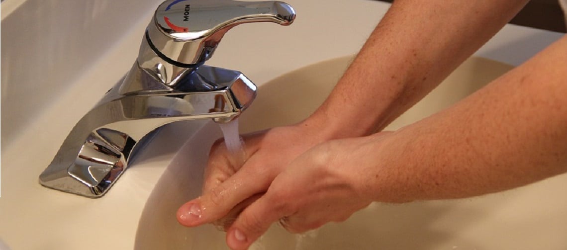 pessoa lavando as mãos em uma pia
