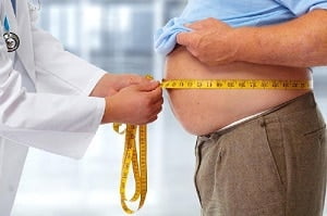 médico medindo barriga de uma pessoa obesa