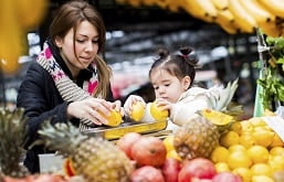 mãe e filha escolhendo frutas no mercado
