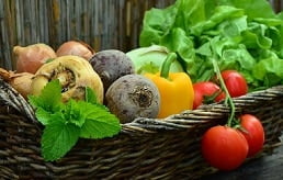 uma cesta com verduras, legumes e ervas