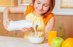 Menina colocando leite no serial