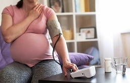 Mulher grávida medindo sua pressão