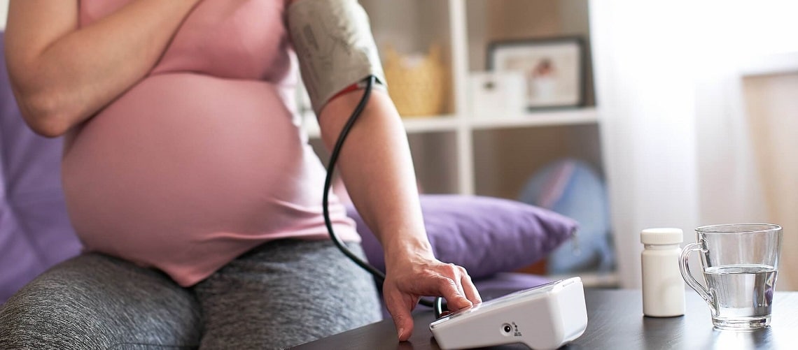 Mulher grávida medindo sua pressão