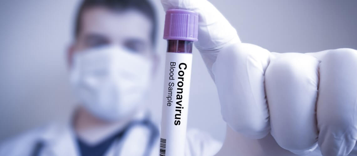 Médico segurando ampola com rótulo escrito: "Coronavírus"