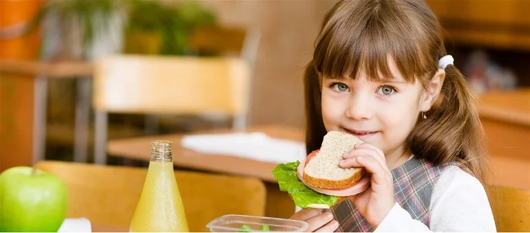 Criança comendo um sanduiche