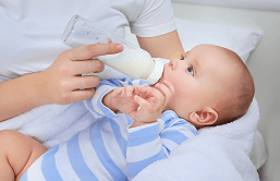 Bebê sendo alimentado na mamadeira