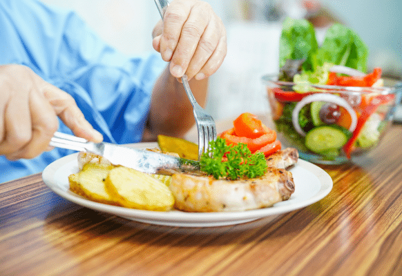imagem de uma pessoa comendo batata e verduras.