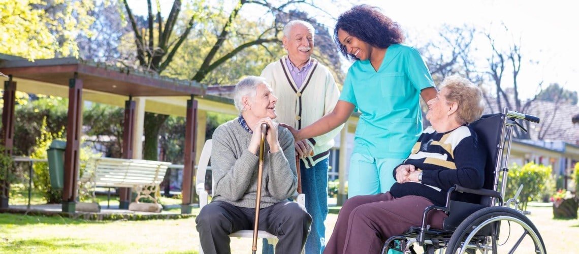 grupo de idosos com uma enfermeira em um jardim