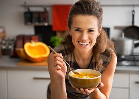 Mulher feliz com bowl de comida na mão