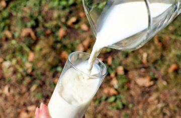 Copo de leite sendo cheio por jarra