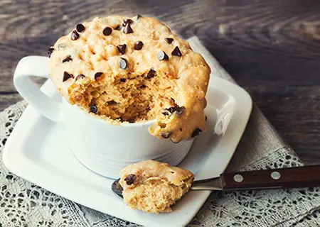 Bolo sem forno, preparado na caneca com gotas de chocolate por cima