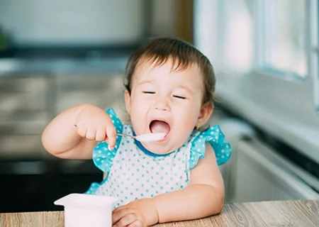 Bebê tomando iogurte