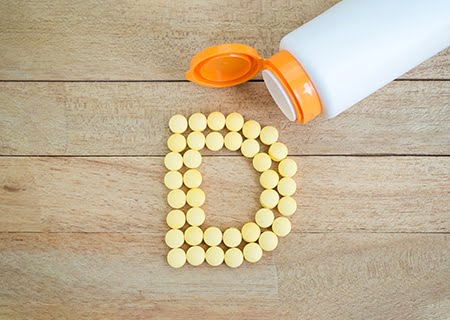 Várias cápsulas de vitamina D formando um "D"
