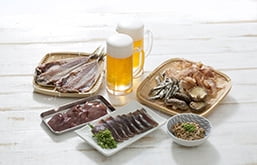 Mesa com carnes e copos de cerveja, alguns dos alimentos ricos em purinas