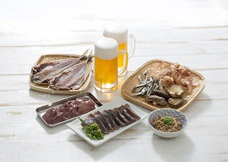 Mesa com carnes e copos de cerveja, alguns dos alimentos ricos em purinas