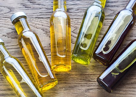 Várias garrafas de vidro com óleos vegetais, alimentos ricos em fitosteróis