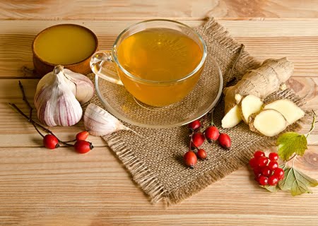 Mesa com chá, gengibre e alho, alguns alimentos indicados para se comer quando estiver com gripe
