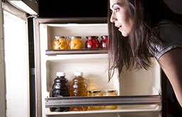 Mulher olhando a geladeira