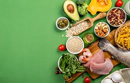 Mesa com diversos alimentos, como abacate, carnes e brócolis, itens que fazem parte da alimentação para controlar pressão alta.
