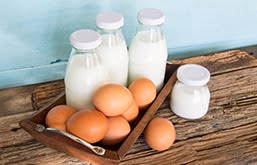Mesa com ovos e garrafas de vidro com leite