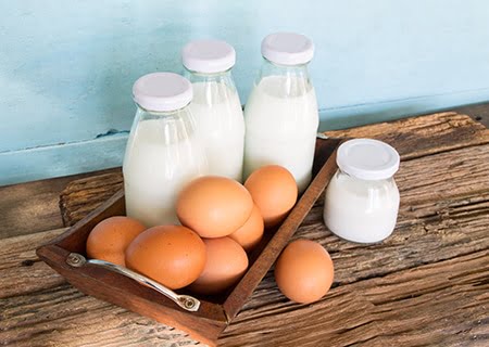 Mesa com ovos e garrafas de vidro com leite