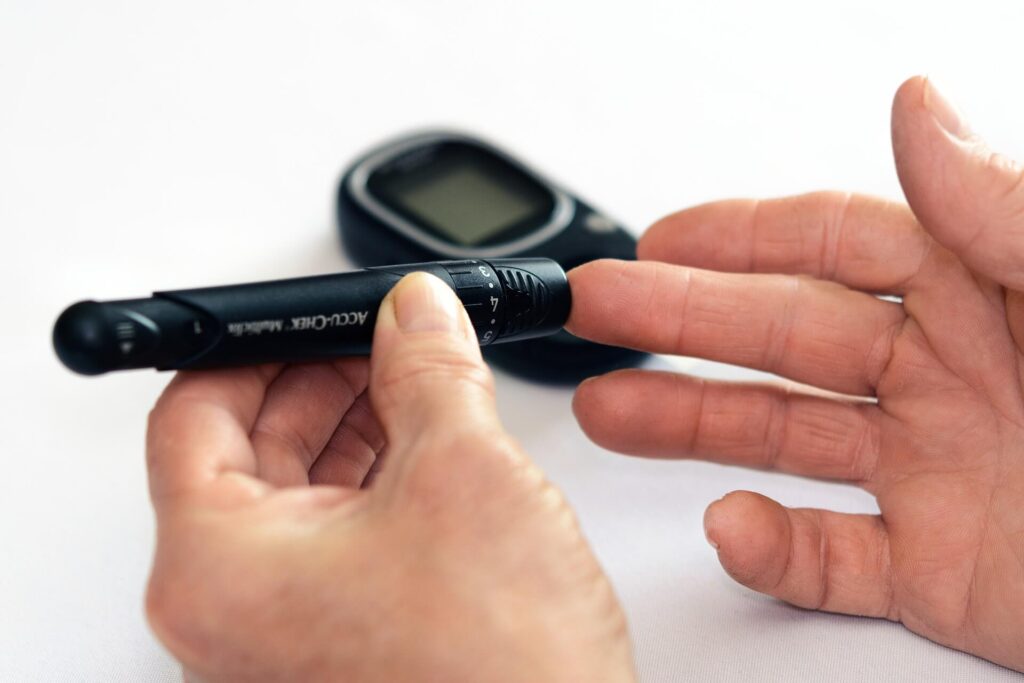 Mão medindo diabetes com aparelho