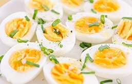 Ovos cozidos cortados ao meio com cheiro-verde