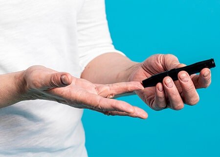 Pessoa medindo glicose no dedo. Imagem: Freepik
