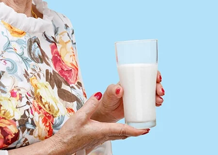 Idosa segurando copo de leite