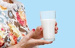 Idosa segurando copo de leite