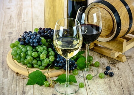 Taças de vinhos, uvas e barril de carvalho