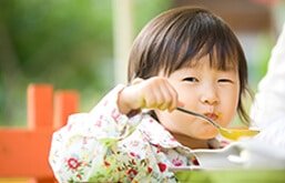 Criança comendo sopa de mandioca cremosa