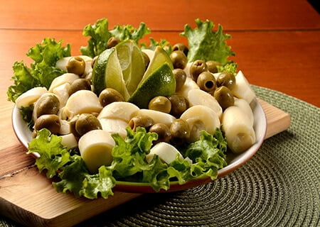 Salada de alface, azeitonas sem caroço e palmito em fatias, com pedaços de limão ao centro