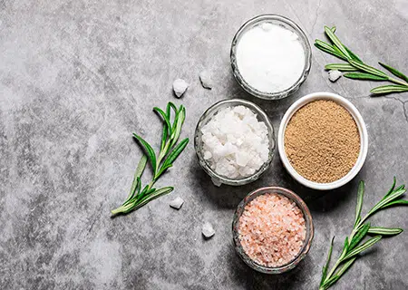 Diversos tipos de sal de cozinha distribuídos em potes