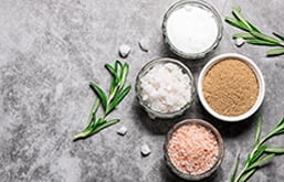 Diversos tipos de sal de cozinha distribuídos em potes