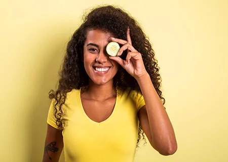 Mulher com pepino nos olhos - para que serve o alimento na beleza?