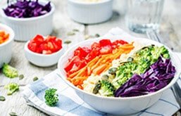 Tigela com vegetais como tomate, cenouras, brócolis e repolho-roxo. Uma sugestão de como montar um prato colorido.