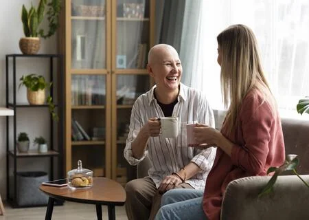 Mulher em tratamento de câncer tomando café com uma amiga