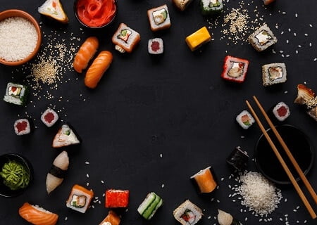 Pratos da culinária japonesa como sushi e sashimi formando um círculo