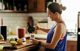 Mulher preparando um shake proteico na cozinha