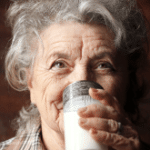 Senhora tomando um copo de leite
