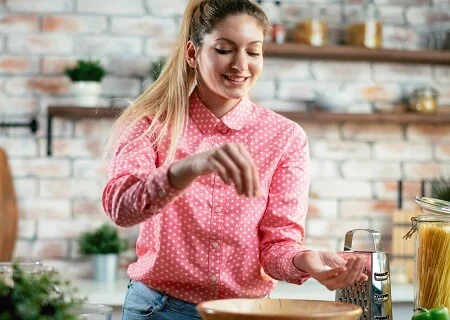 Moça temperando comida com sal