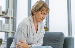 Mulher sentindo dores causadas pela gastrite
