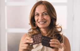 Mulher comendo chocolate pós-menopausa