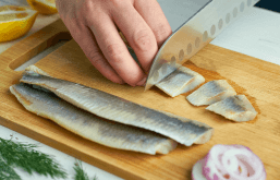Cortando peixe em uma tábua para a dieta nórdica