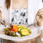 Mulher comendo um prato da dieta anti-inflamatória