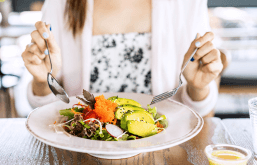 Mulher comendo um prato da dieta anti-inflamatória