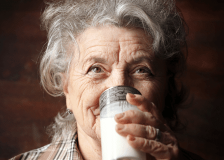 Senhora tomando um copo de leite